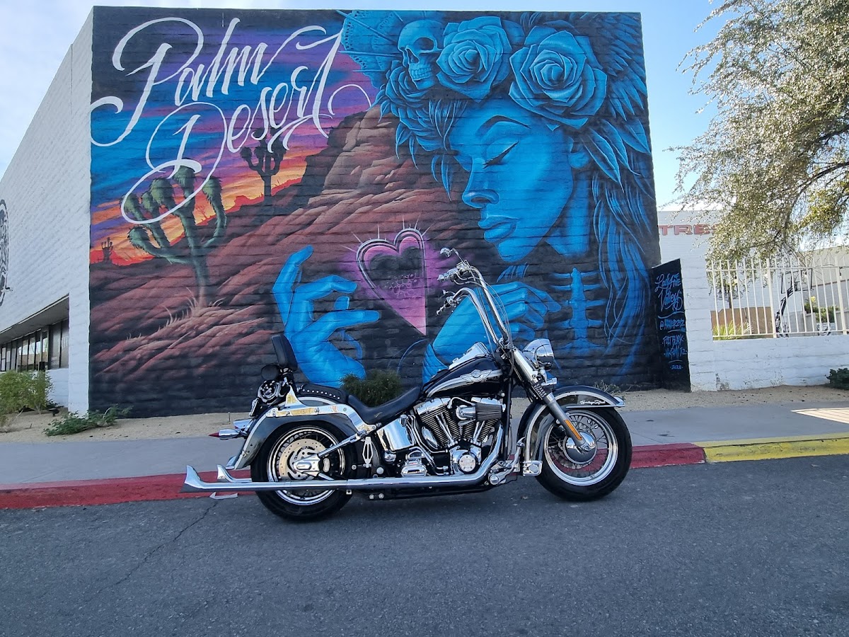 InkFamy Tattoo building mural — desert sunset with Joshua trees, Chicano script lettering